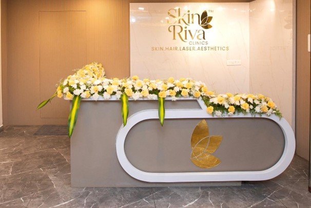 Oval reception desk with floral display and Skin Riva gold leaf brand mark